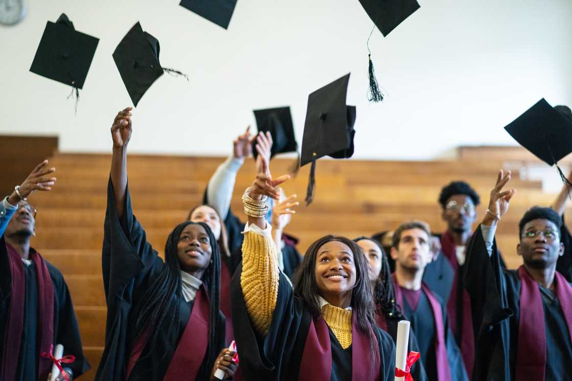 Graduates tossing caps into the air