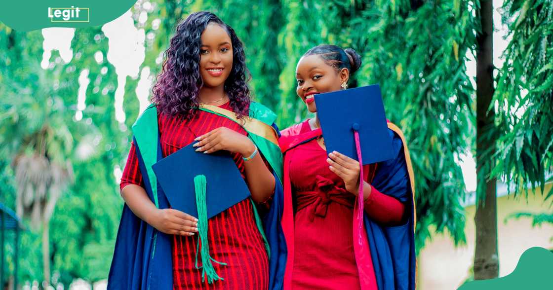 Two female students in blue graduation gowns and caps.