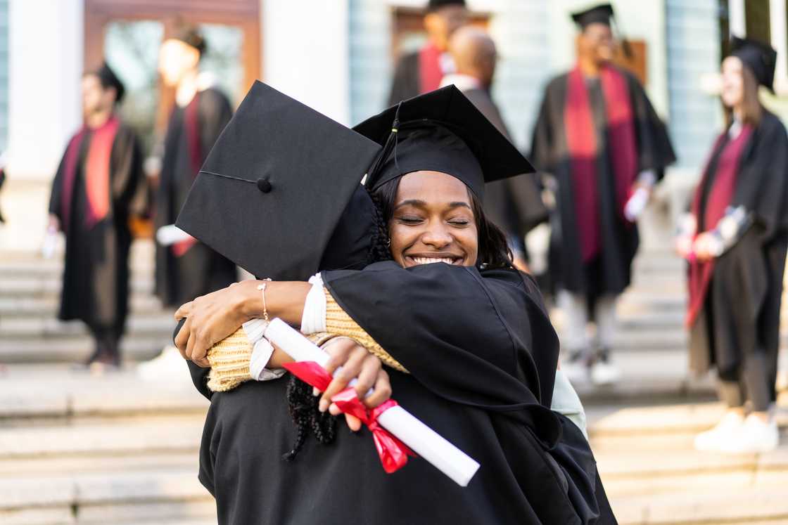 Graduates hugging each other after receiving their diplomas