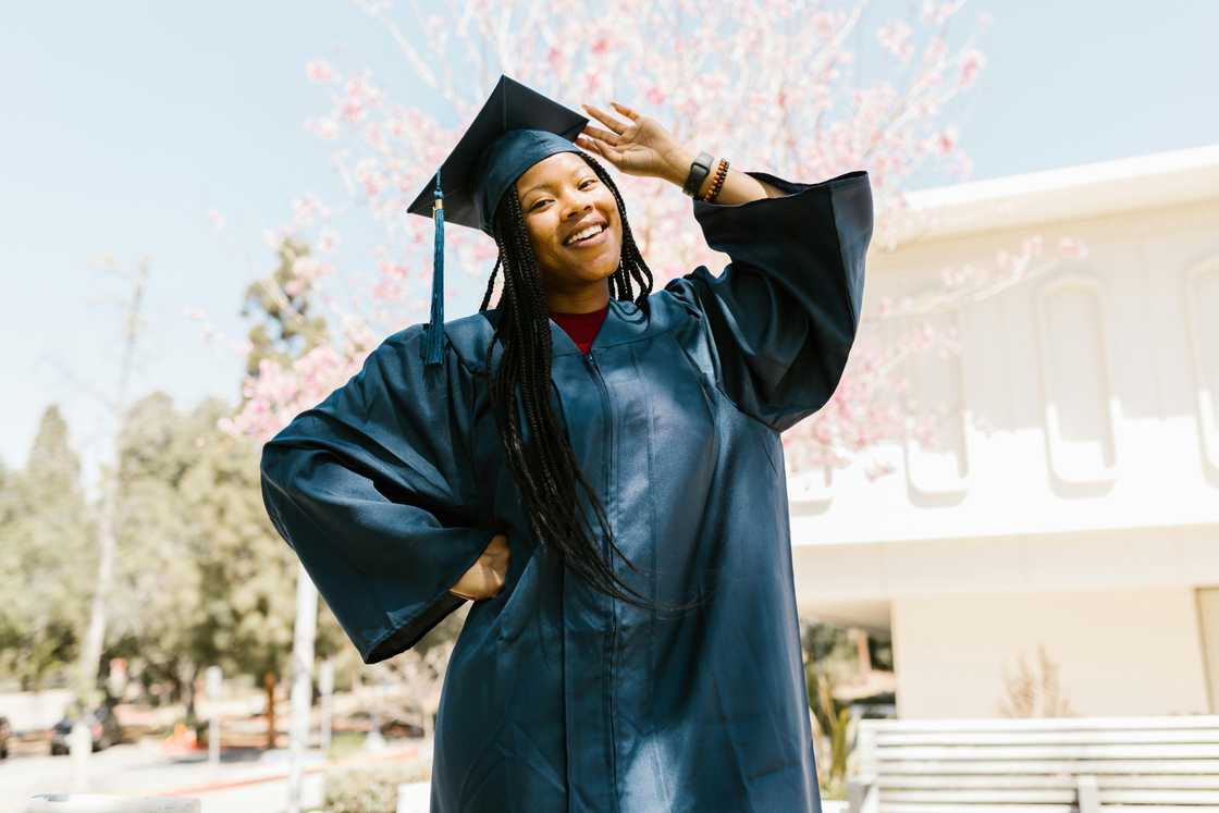 A lady wearing a graduation attire posing for a photo