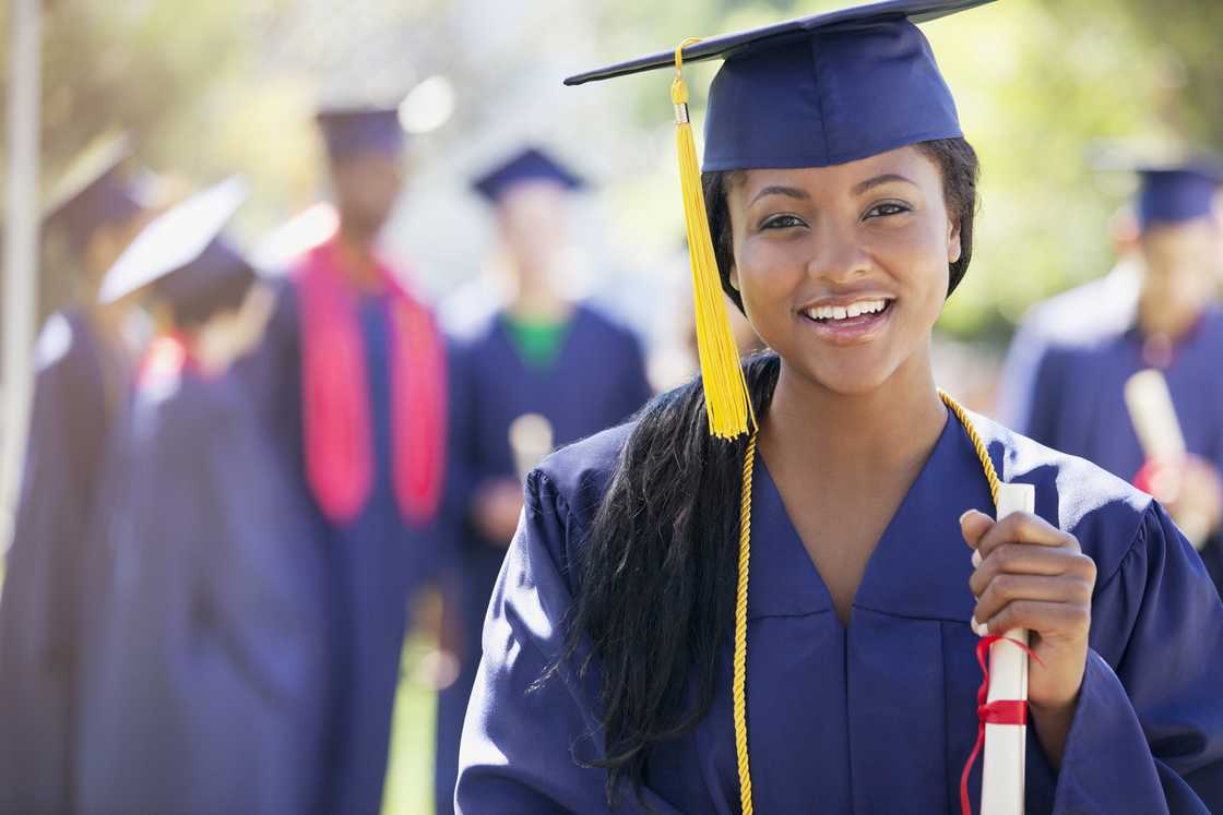 A graduate holding a diploma