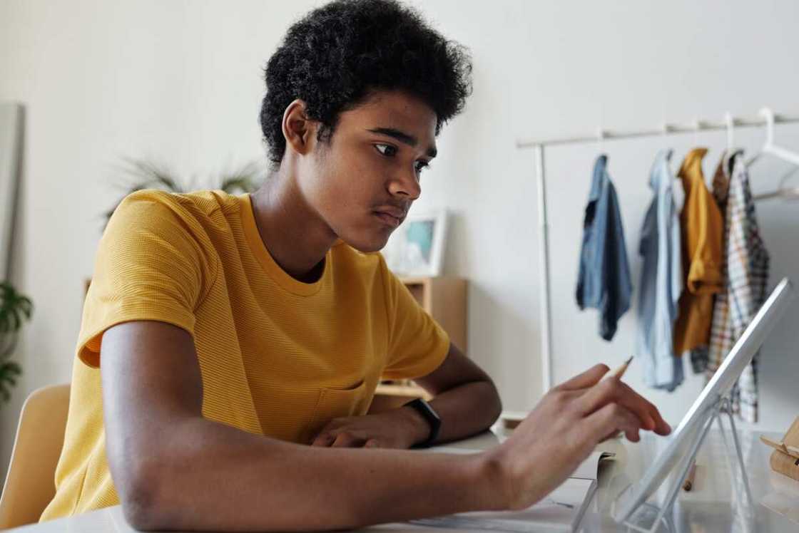 A male student in yellow top studying