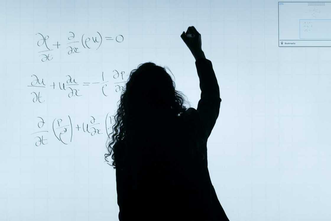 A teacher writing on a whiteboard