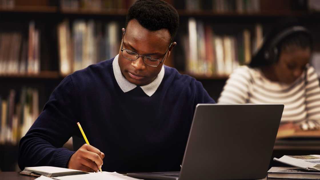 A student is pictured studying in a library.