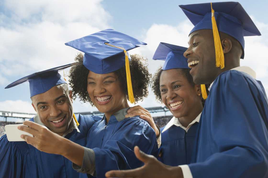 Students taking cell phone selfie at graduation